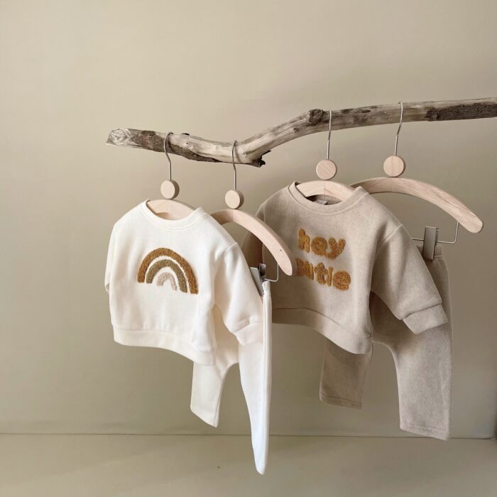 e7f96142-1ed6-4a51-9190-f4b9e227aaa5.jpg Cute baby wearing a neutral creamy-white baby embroidered two piece outfit.