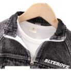 Stylish little boy smiling outdoors in a cool boys denim terno set.