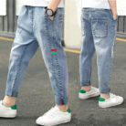 Close-up of the neat waistband and comfortable cotton fabric on kids casual denim pants.