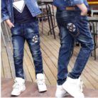 Close-up of the neat waistband and comfortable cotton fabric on kids casual denim pants.