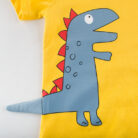 A happy little boy wearing a cute kids dinosaur shirt for summer play.