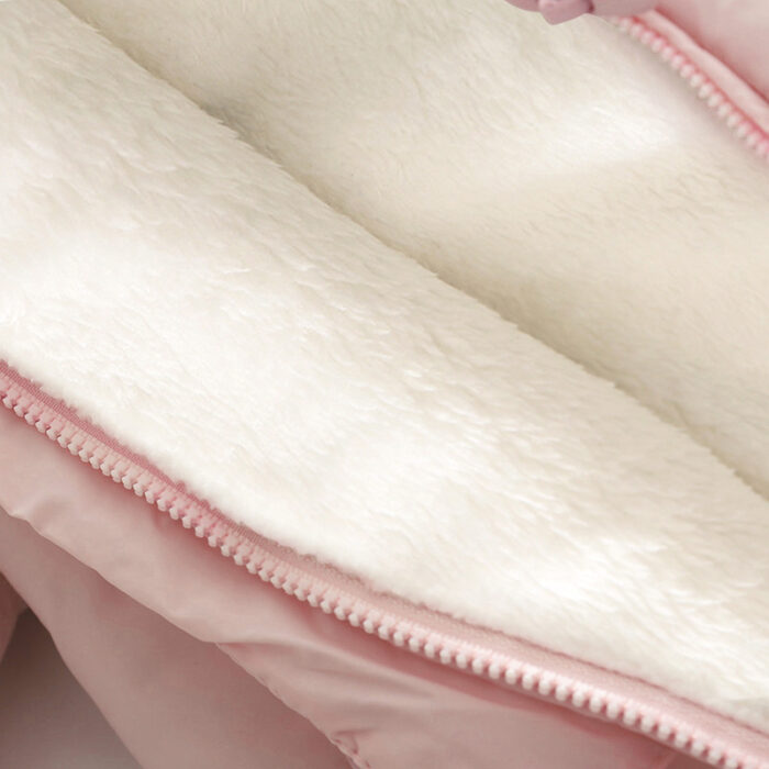 An adorable baby staying warm in a thick baby winter snowsuit with mittens.
