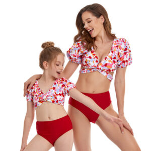 Beautiful mom and her little girl at the beach wearing a mommy and me twinning swimsuit.