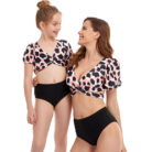 Beautiful mom and her little girl at the beach wearing a mommy and me twinning swimsuit.