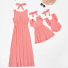 Beautiful mom and her little girl wearing a matching mother and daughter twinning dress.