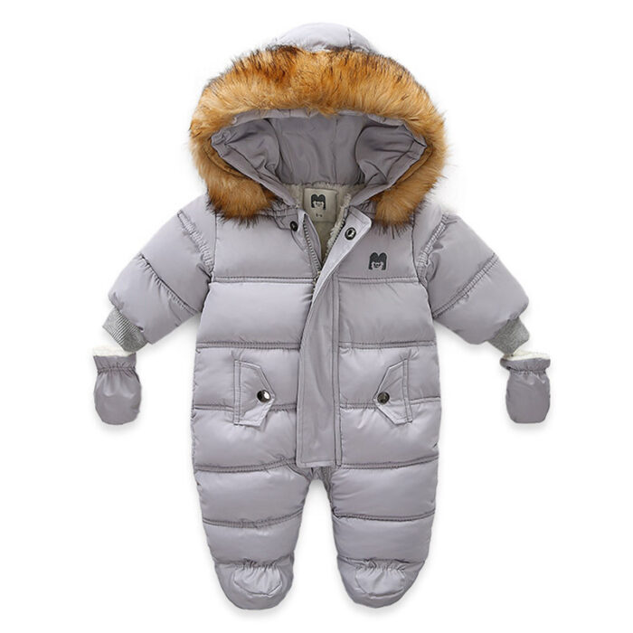 An adorable baby staying warm in a thick baby winter snowsuit with mittens.