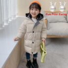 A happy child staying warm in the snow wearing a stylish kids thick winter coat.