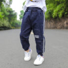 Close-up of the neat waistband and comfortable cotton fabric on kids casual denim pants.
