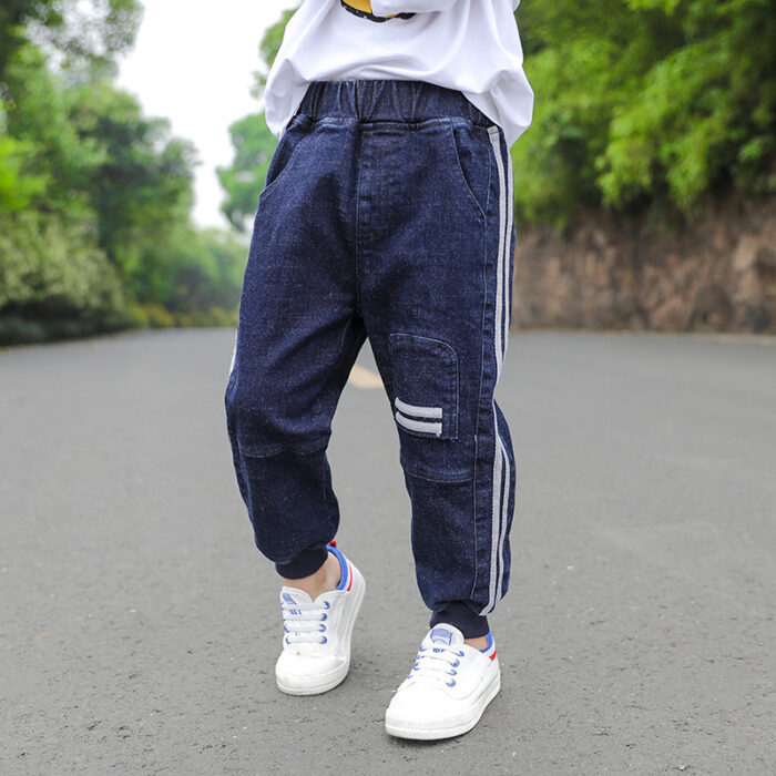 Close-up of the neat waistband and comfortable cotton fabric on kids casual denim pants.