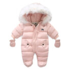 An adorable baby staying warm in a thick baby winter snowsuit with mittens.