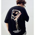A stylish man wearing a trendy mens oversized graphic t shirt with a paint splatter design.