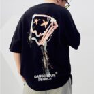 A stylish man wearing a trendy mens oversized graphic t shirt with a paint splatter design.