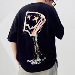 A stylish man wearing a trendy mens oversized graphic t shirt with a paint splatter design.