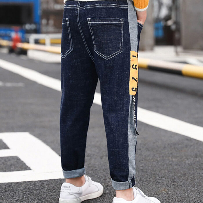 Close-up of the neat waistband and comfortable cotton fabric on kids casual denim pants.