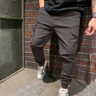 Stylish young man wearing trendy mens casual cargo pants with utility pockets.