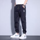 Stylish young man wearing comfortable mens denim jogger pants.