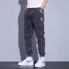 Stylish young man wearing comfortable mens denim jogger pants.