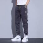 Stylish young man wearing comfortable mens denim jogger pants.