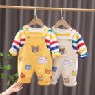 An adorable little boy ready for a party wearing a toddler boy overalls and shirt set from K&K trend Wear.