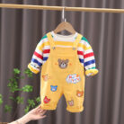 An adorable little boy ready for a party wearing a toddler boy overalls and shirt set from K&K trend Wear.